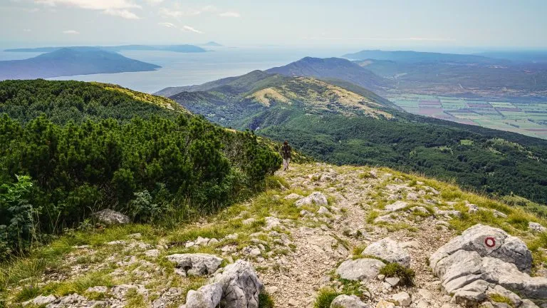 Spaziergang auf einem Wanderweg auf dem Gipfel des Berges Voyak, Istrien. Auf der linken Seite sind die Inseln Krk und Cres zu sehen